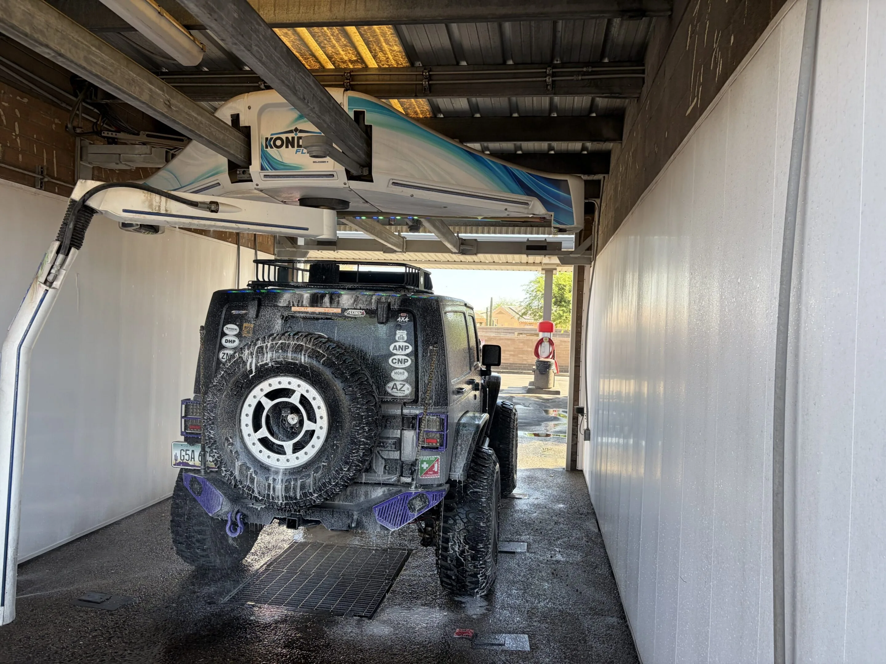 Jeep parked in a garage with a boat on top of it