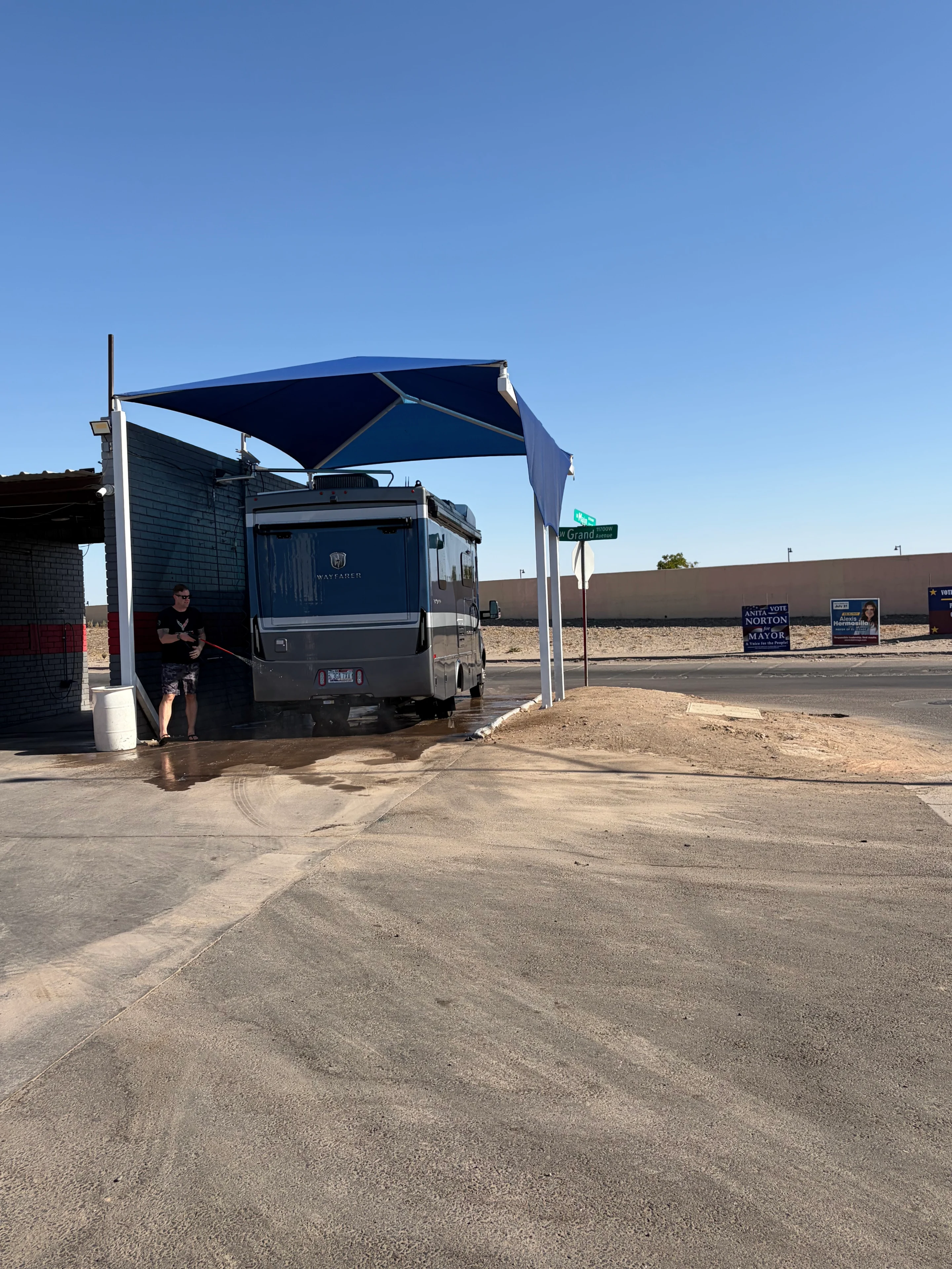 RV under blue canopy at car wash.