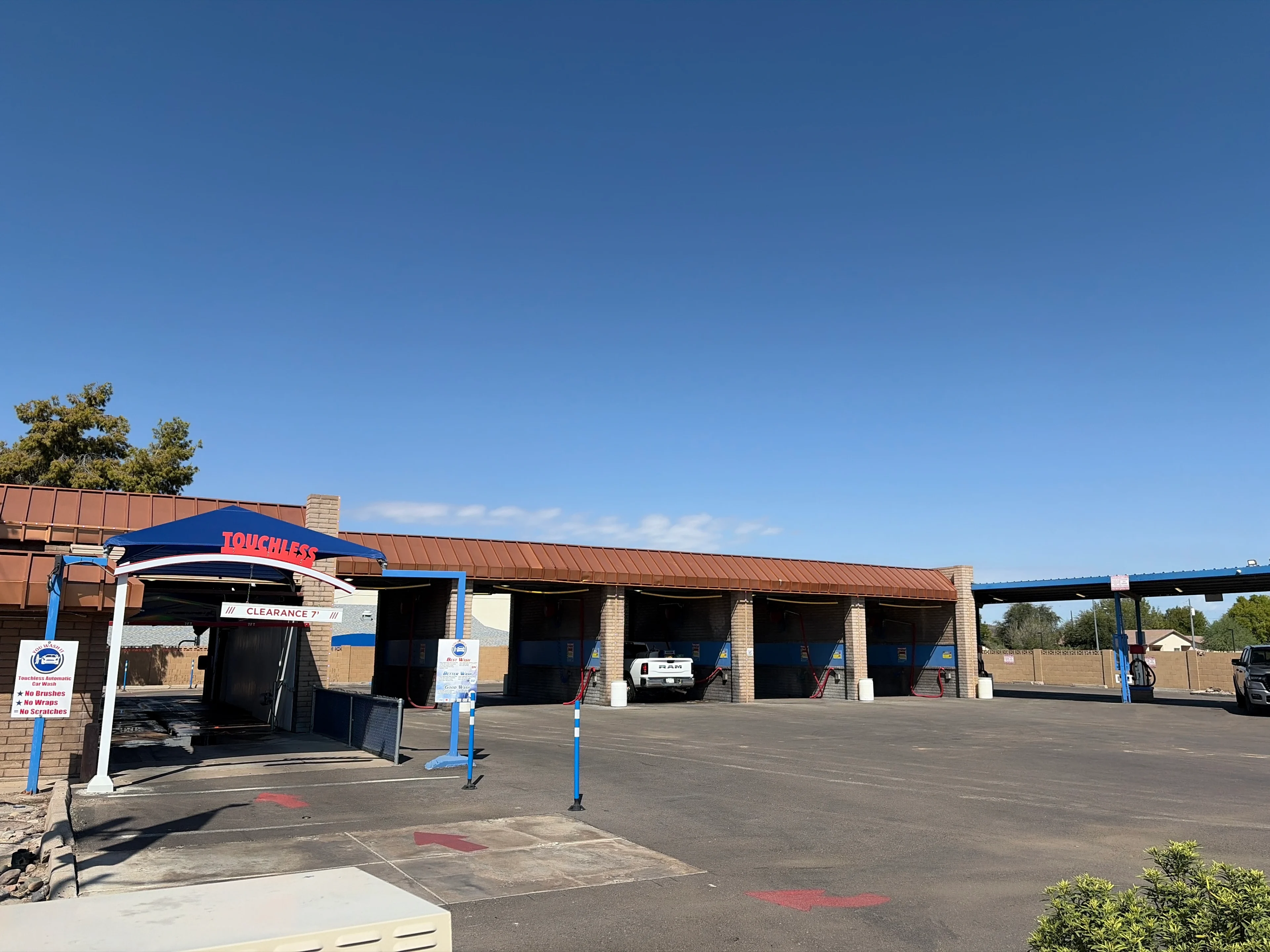 Car wash facility under clear blue sky.