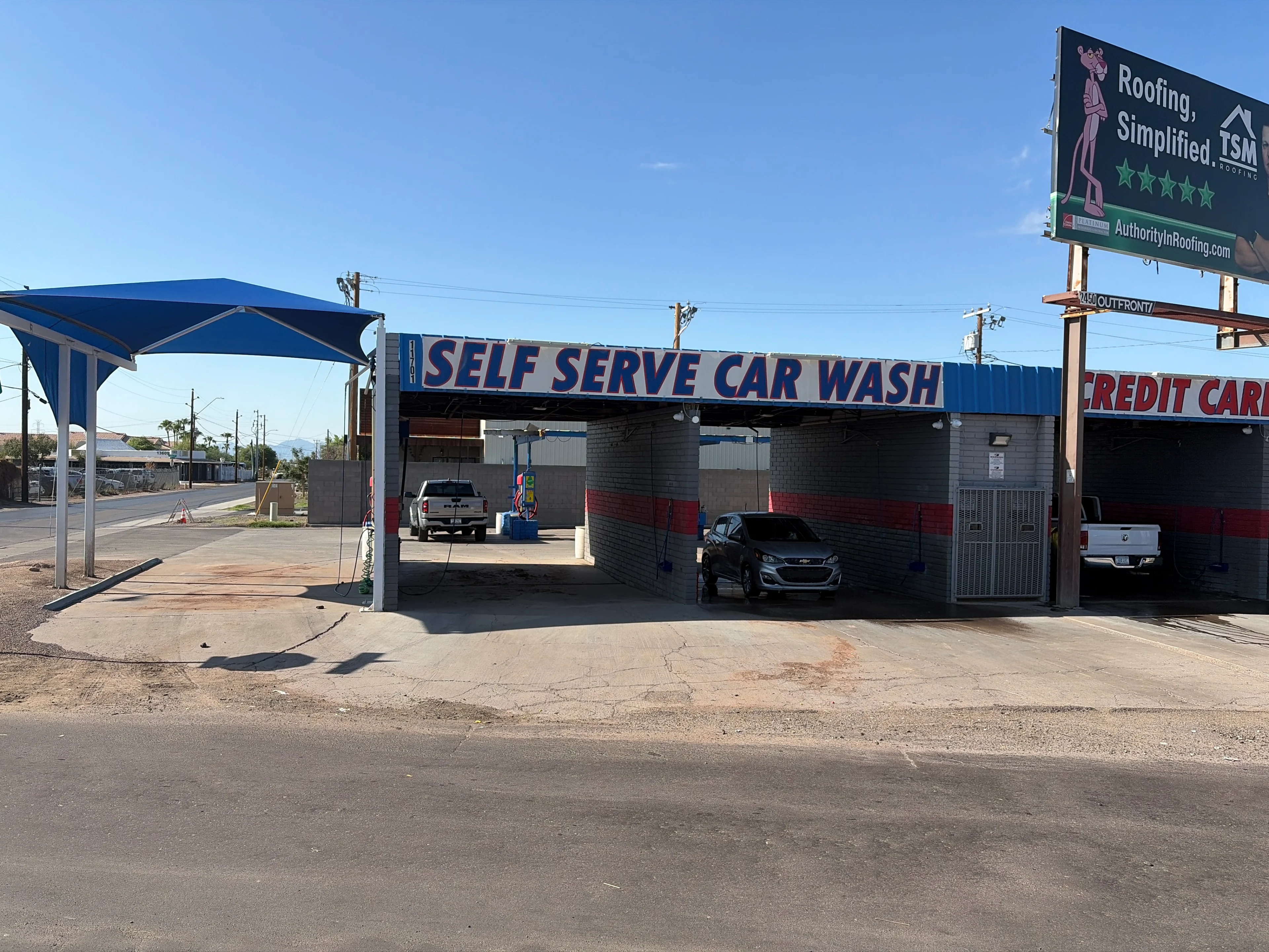 Self-serve car wash with parked cars.